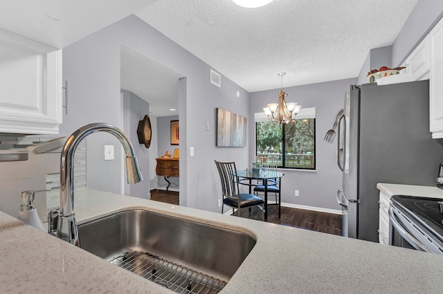 kitchen featuring dark hardwood / wood-style flooring, sink, decorative light fixtures, white cabinets, and a chandelier