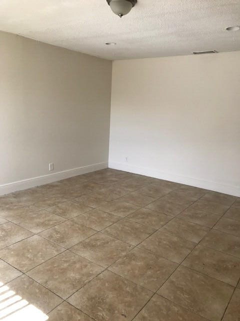 unfurnished room with a textured ceiling