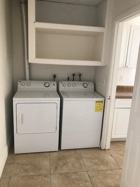 washroom with light tile patterned flooring and washer and dryer