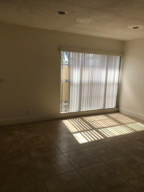 spare room featuring a textured ceiling and dark tile patterned floors