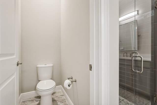 bathroom featuring toilet and a shower with door