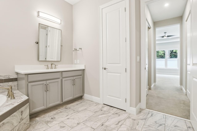 bathroom with vanity, ceiling fan, and a tub