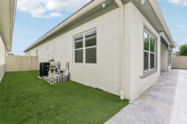 view of property exterior with a yard and central air condition unit