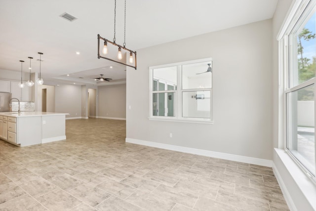 kitchen with a wealth of natural light, ceiling fan, sink, and pendant lighting