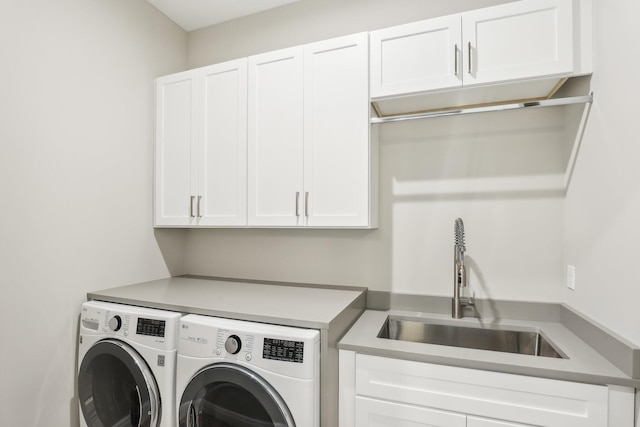 laundry area featuring cabinets, sink, and washer and dryer