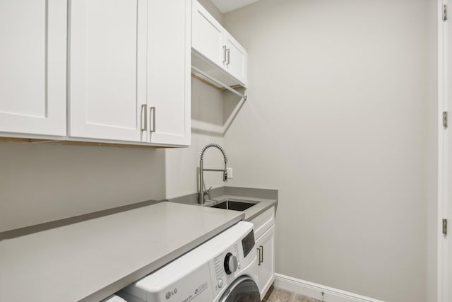 laundry room with sink, cabinets, and washer / dryer