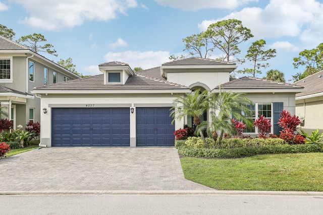 mediterranean / spanish home featuring a front lawn and a garage