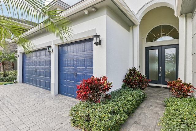 view of exterior entry featuring french doors and a garage