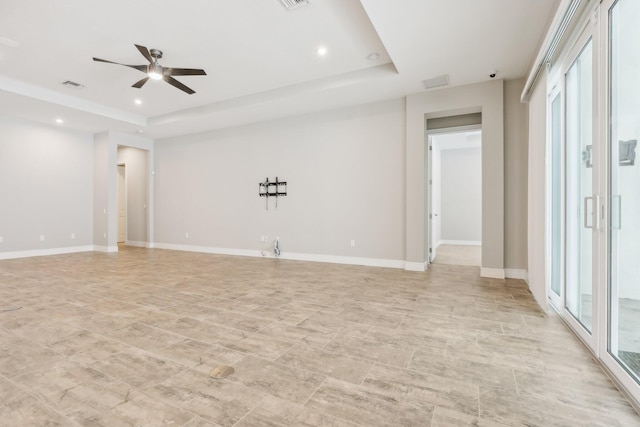 unfurnished room with ceiling fan and a raised ceiling