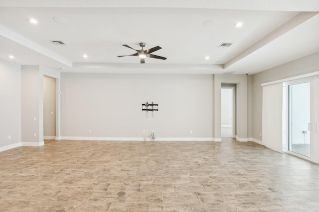 unfurnished room with a raised ceiling and ceiling fan