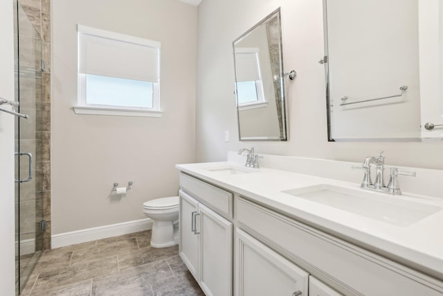 bathroom with vanity, toilet, and a shower with door