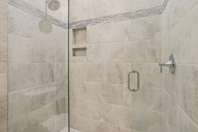 bathroom featuring a shower with shower door