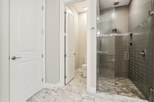 bathroom with a shower with door and toilet