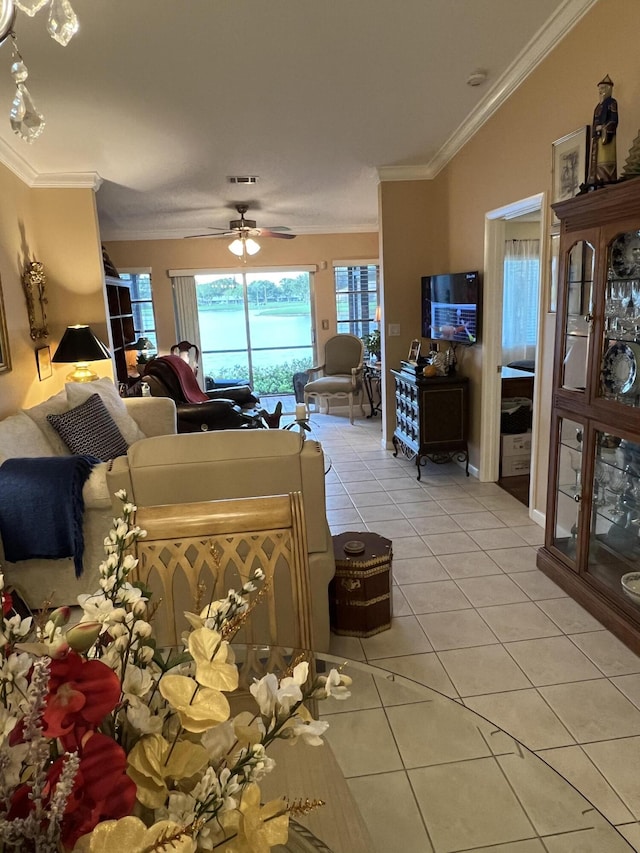 interior space featuring ceiling fan, light tile patterned flooring, and crown molding