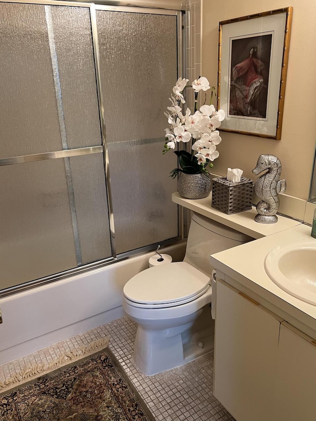 full bathroom featuring tile patterned flooring, vanity, toilet, and shower / bath combination with glass door