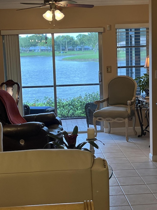 tiled living room featuring a water view and ceiling fan