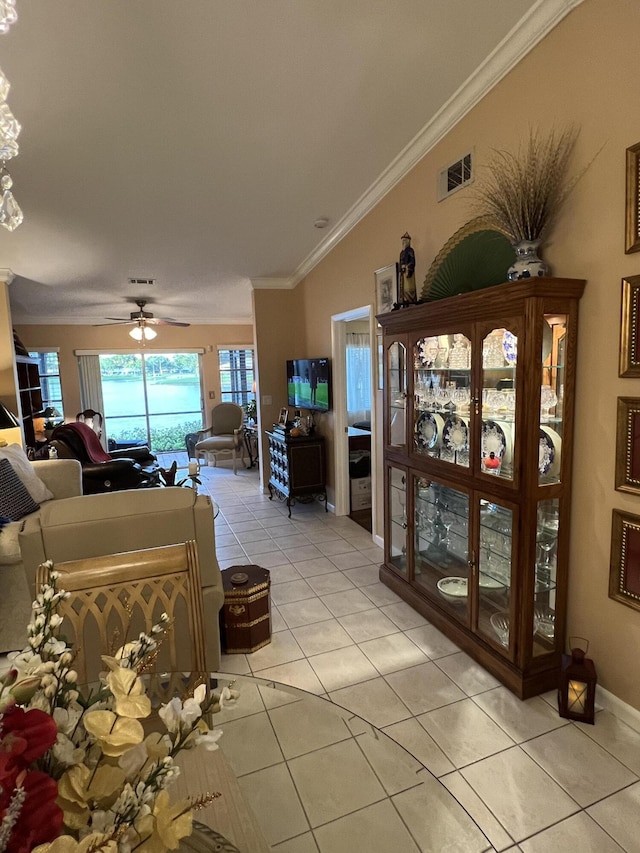 living room featuring ceiling fan, light tile patterned floors, and crown molding