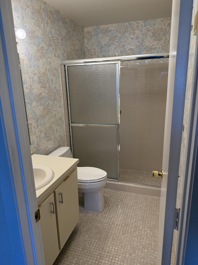 bathroom with walk in shower, tile patterned flooring, vanity, and toilet