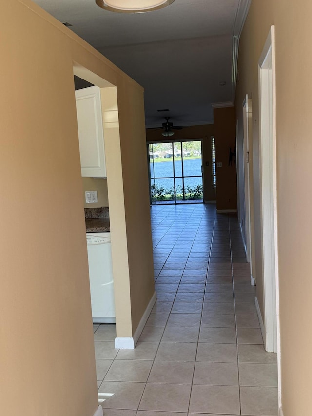 hallway with crown molding and light tile patterned flooring