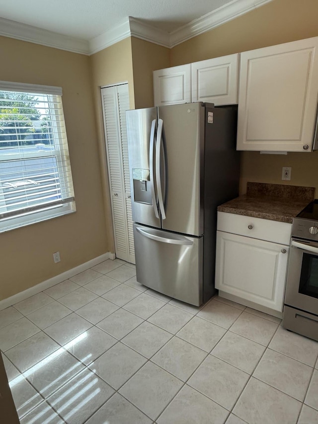 kitchen featuring white cabinetry, light tile patterned floors, stainless steel appliances, and ornamental molding