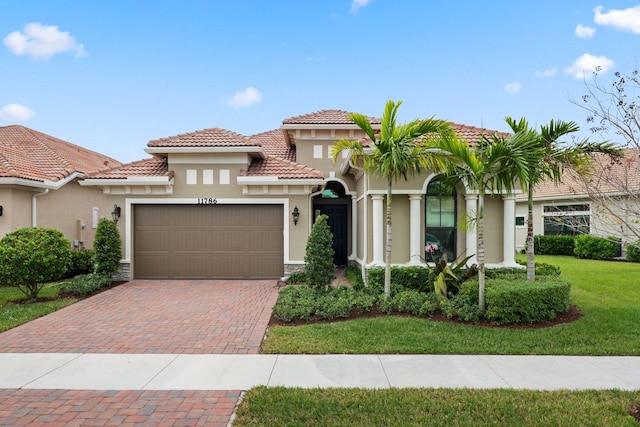 mediterranean / spanish house featuring a front lawn and a garage