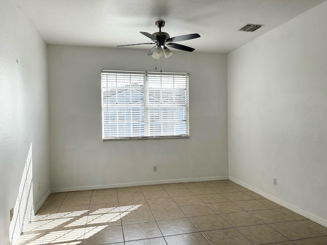 spare room featuring light tile patterned floors and ceiling fan