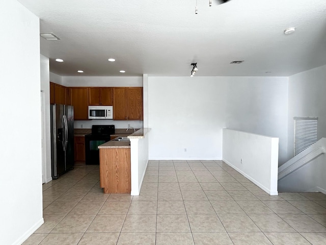 kitchen with light tile patterned flooring, stainless steel fridge with ice dispenser, black range with electric cooktop, and sink