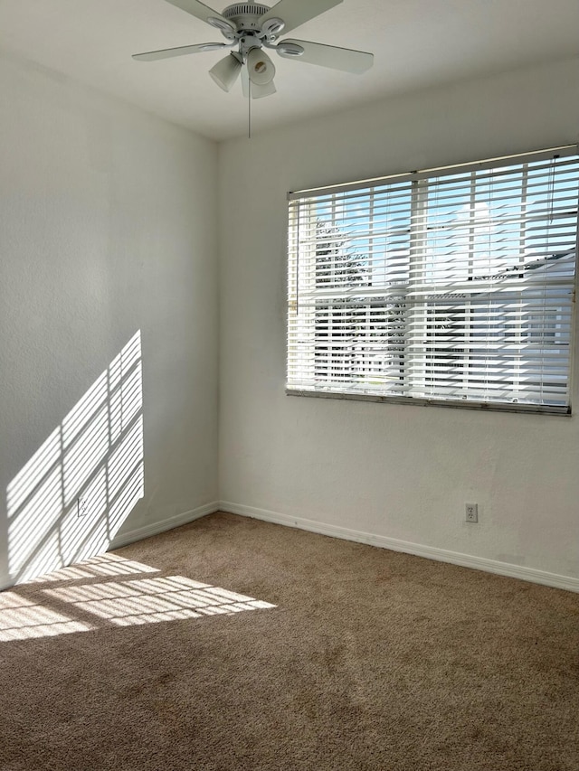 spare room featuring ceiling fan and carpet