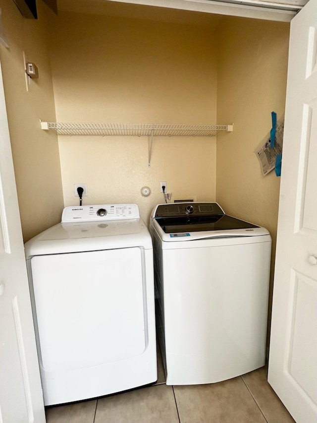 laundry area with light tile patterned flooring and washing machine and clothes dryer