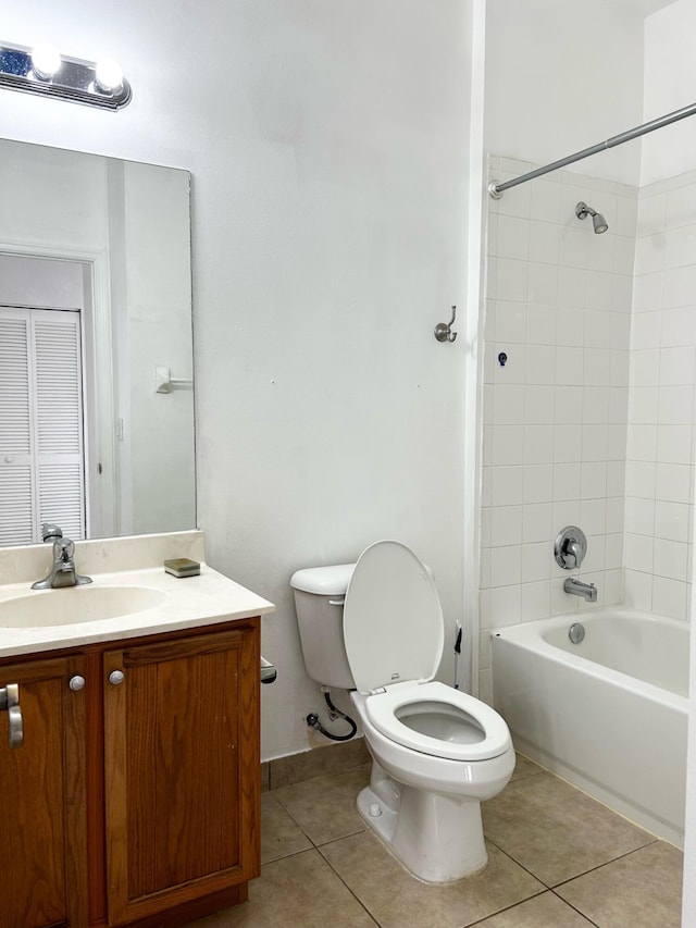 full bathroom with tile patterned floors, tiled shower / bath, vanity, and toilet