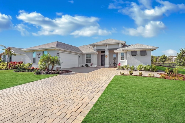 prairie-style house featuring a garage, stucco siding, decorative driveway, and a front yard