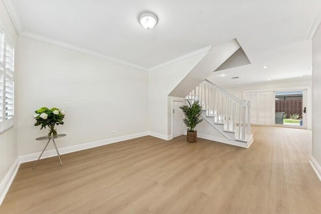 unfurnished living room with a healthy amount of sunlight, ornamental molding, and light wood-type flooring