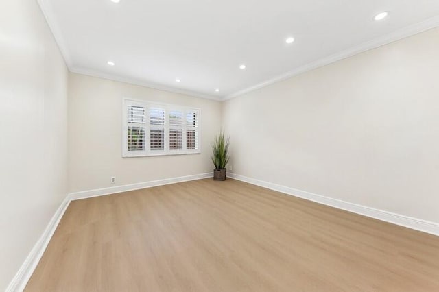 spare room featuring crown molding and light wood-type flooring