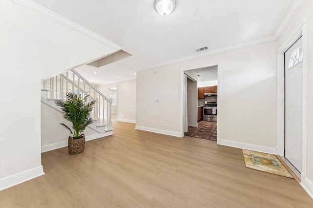 living room with ornamental molding, a healthy amount of sunlight, and light hardwood / wood-style flooring