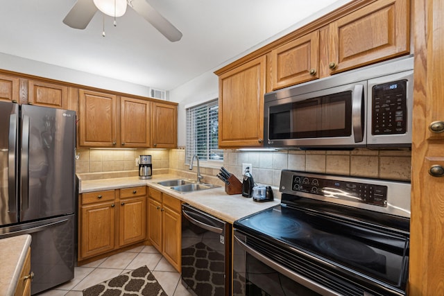 kitchen featuring a sink, light countertops, tasteful backsplash, and stainless steel appliances