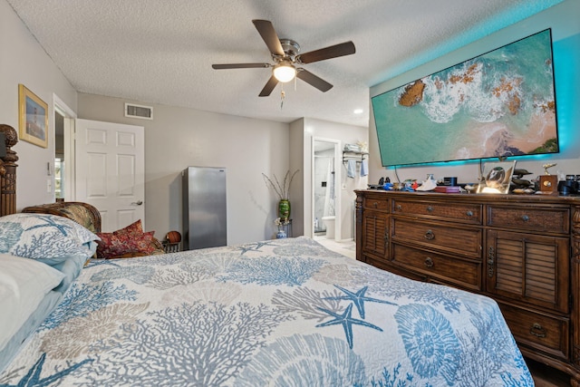 bedroom featuring connected bathroom, visible vents, a textured ceiling, and ceiling fan