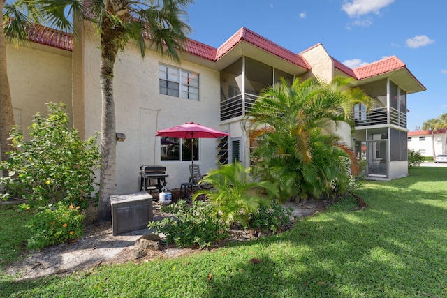 312 Lake Dora Dr, West Palm Beach, FL 33411 - back of house featuring stucco siding, a lawn, a balcony, and a tile roof