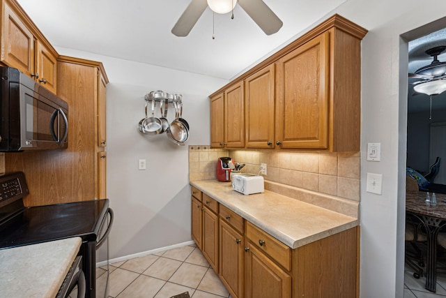 kitchen with brown cabinets, backsplash, black appliances, and light countertops