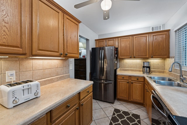 kitchen with brown cabinetry, visible vents, black appliances, and a sink