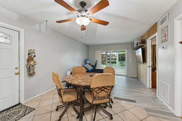 dining area with visible vents, a textured ceiling, light wood-type flooring, and a ceiling fan