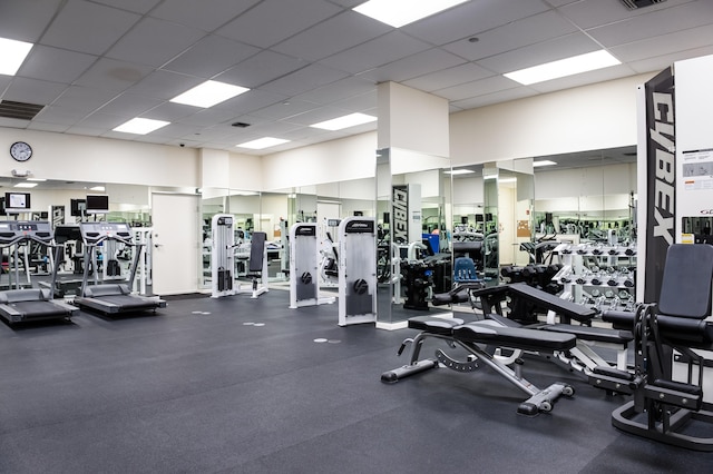 gym with a paneled ceiling and a high ceiling