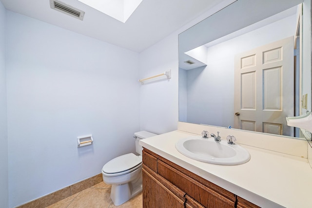 bathroom with toilet, vanity, and tile patterned floors