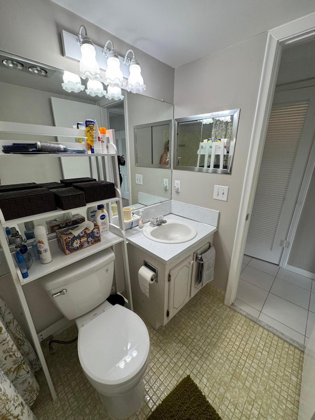 bathroom featuring tile patterned floors, vanity, and toilet