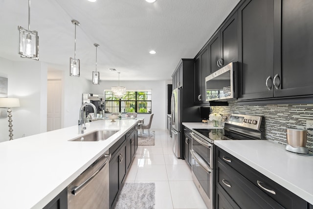 kitchen featuring decorative backsplash, sink, stainless steel appliances, and decorative light fixtures