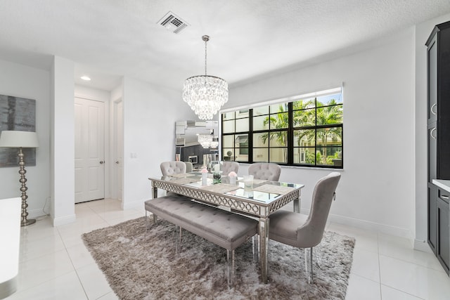 dining space featuring a notable chandelier, light tile patterned flooring, and a textured ceiling