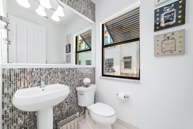 bathroom with tile walls and toilet