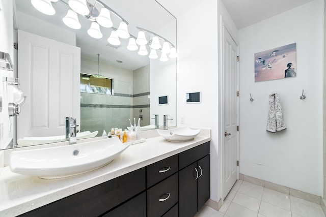 bathroom featuring tile patterned floors, vanity, and a tile shower