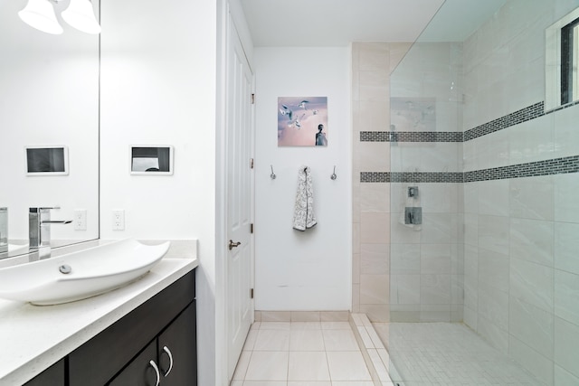 bathroom with tile patterned floors, vanity, and tiled shower