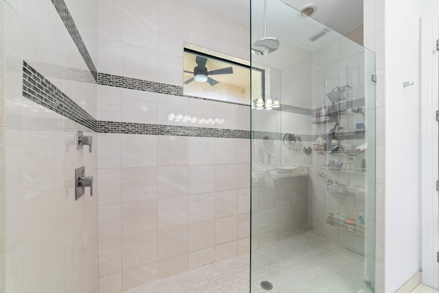 bathroom with ceiling fan and tiled shower