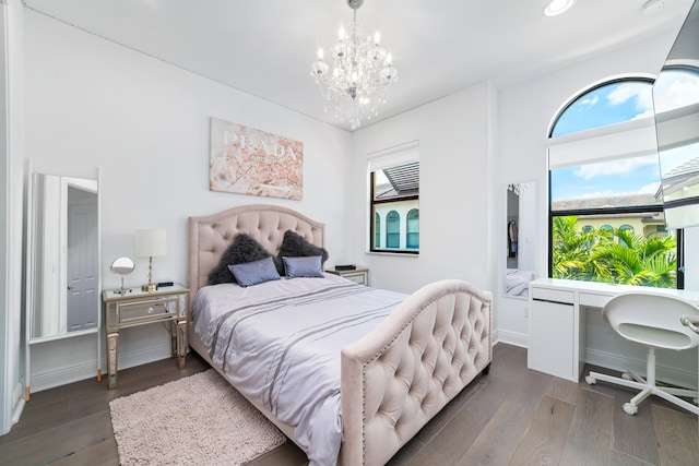 bedroom with a notable chandelier and dark wood-type flooring